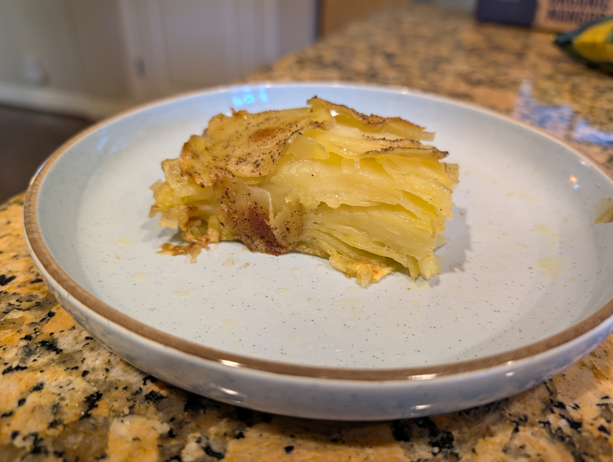 A slice of baked potatoes arranged with flat slices, showing the clean layer and crispy top