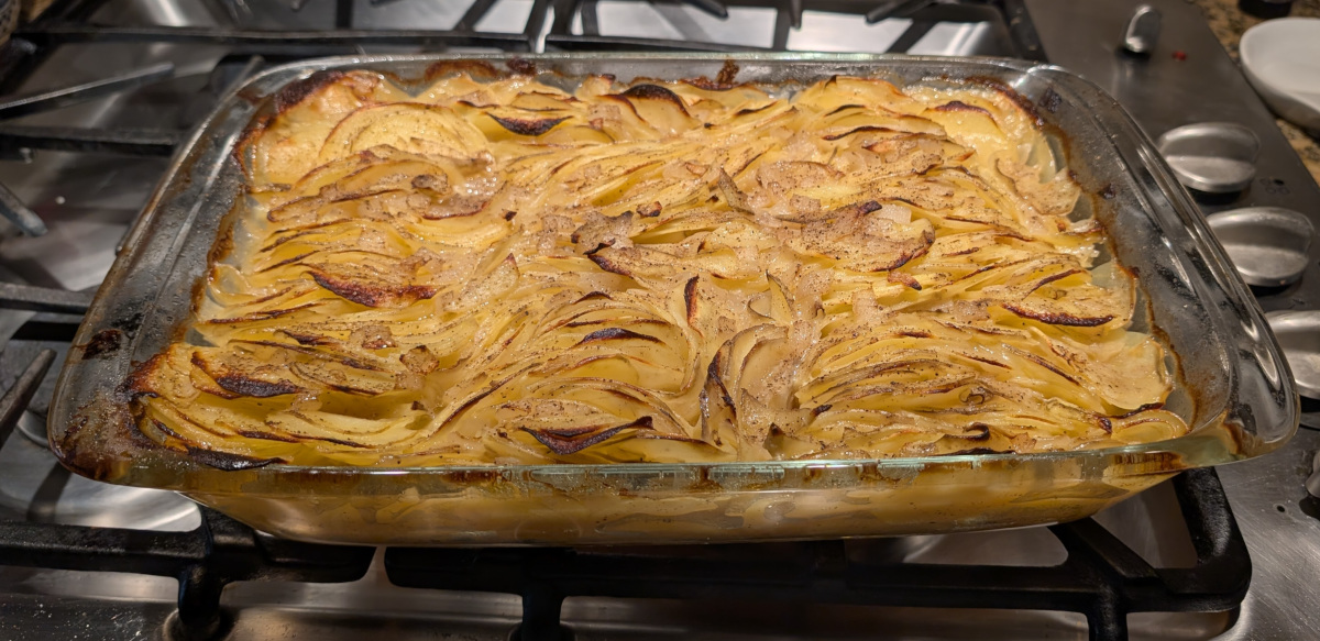 Baked potato slices neatly arranged with slices edge-up, with browned edges